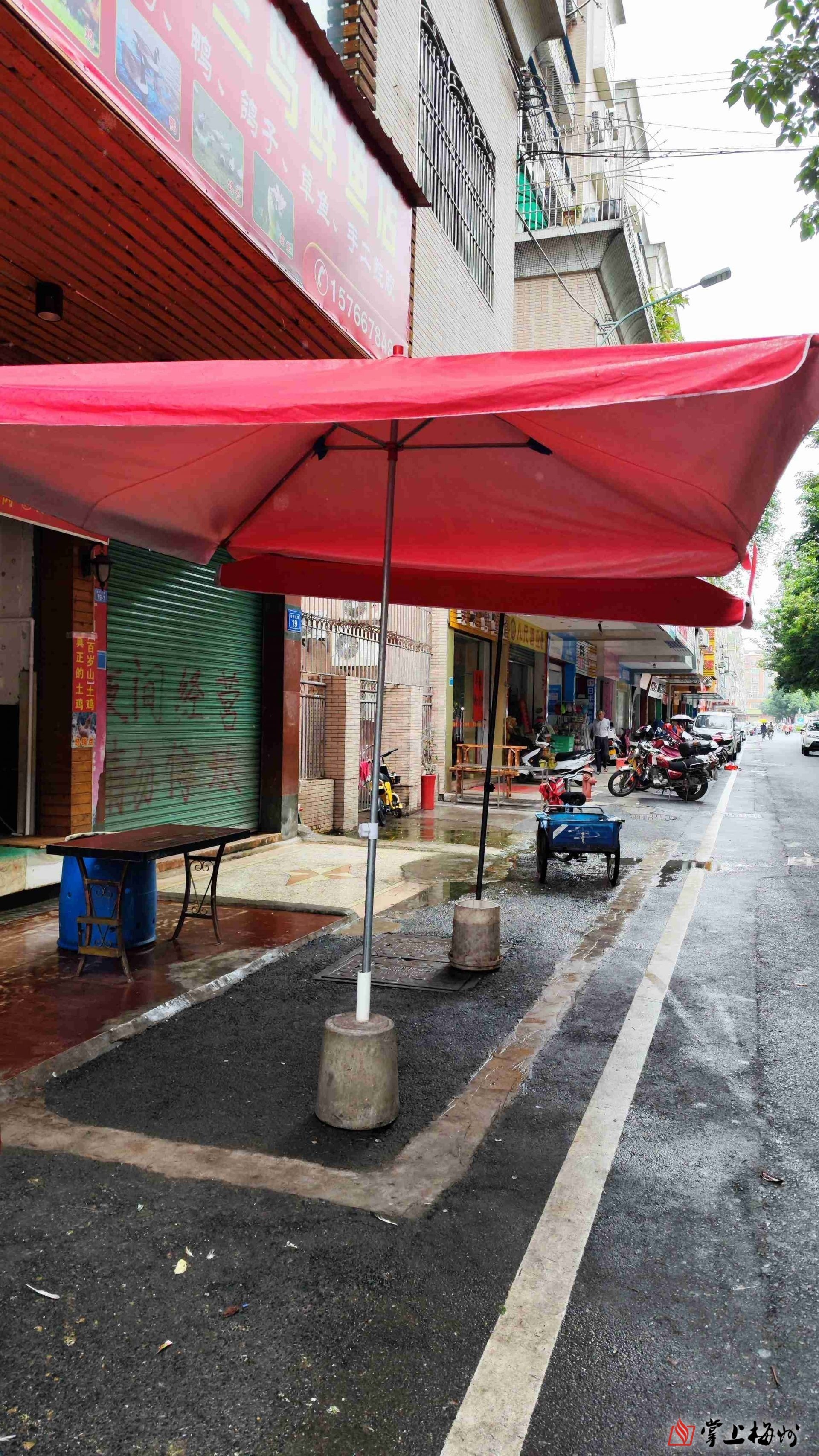 店家直接在公共车位上放置水泥石墩, 撑起太阳伞.