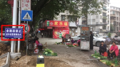 形同虚设！“禁止摆摊设点”提示牌下，数个摊贩沿街摆卖…