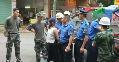 梅城瓜园市场，一名猪肉店女店主占道经营还持刀抗法...