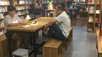 梅城书店“风景”： 书籍被当了手机“支架”