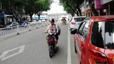 机动车道载孩子逆行，梅城这些家长该反省一下...