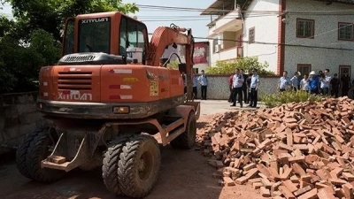 忌讳送葬队伍经过家门口，梅江区一对父子竟搬砖堵路…