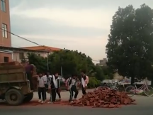 暖心！丰顺一拖拉机砖掉一地，学生路过援手相助