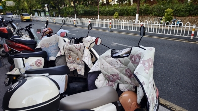 梅城电动车摩托车加装挡风被成“冬日标配”，温暖和安全谁更重要？